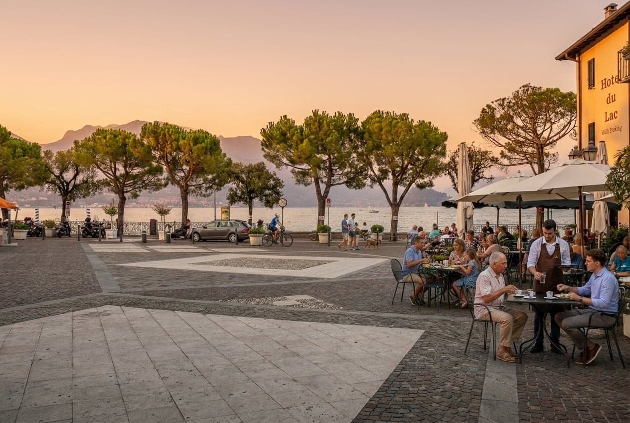 Diners on a lakeside terrace in Menaggio in the warm light of early evening