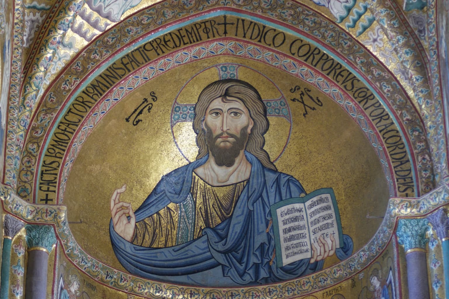 The gold apse mosaic of Christ Pantocrator in Cefalù cathedral, his right hand raised in blessing and an open book in the other