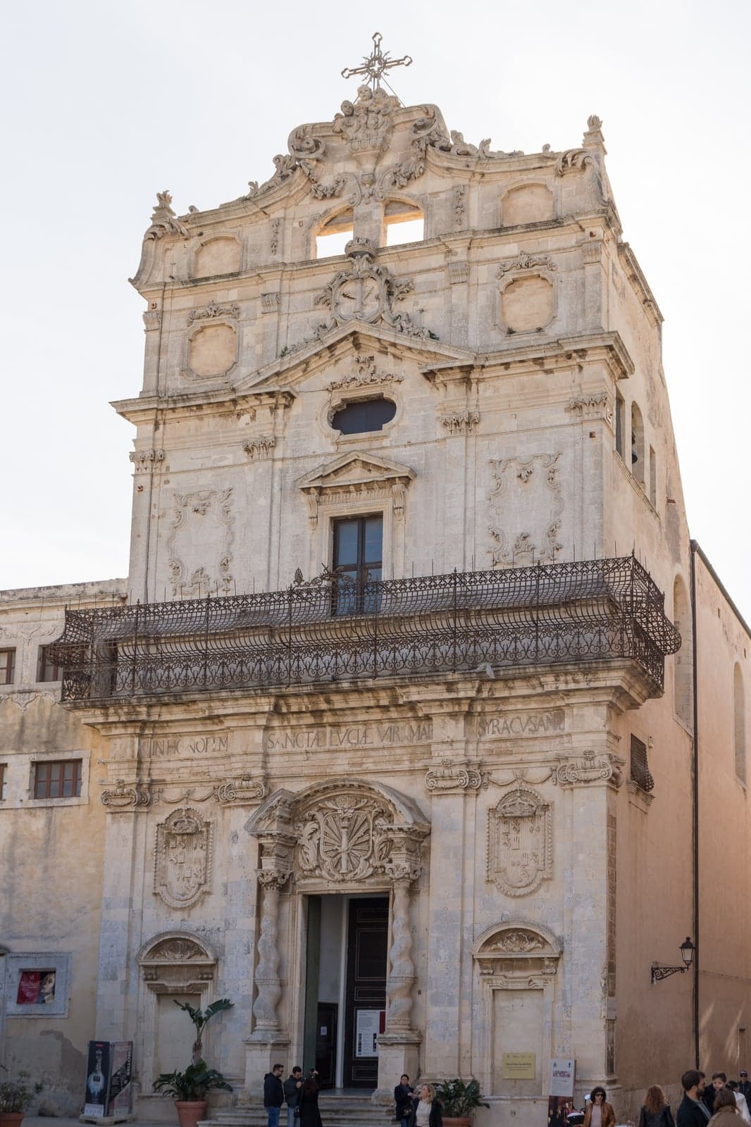 Santa Lucia alla Badia's baroque façade on Piazza Duomo in daylight, the inscription "SANCTAE LVCIAE VIRG MAR SYRACVSANA" over the entrance