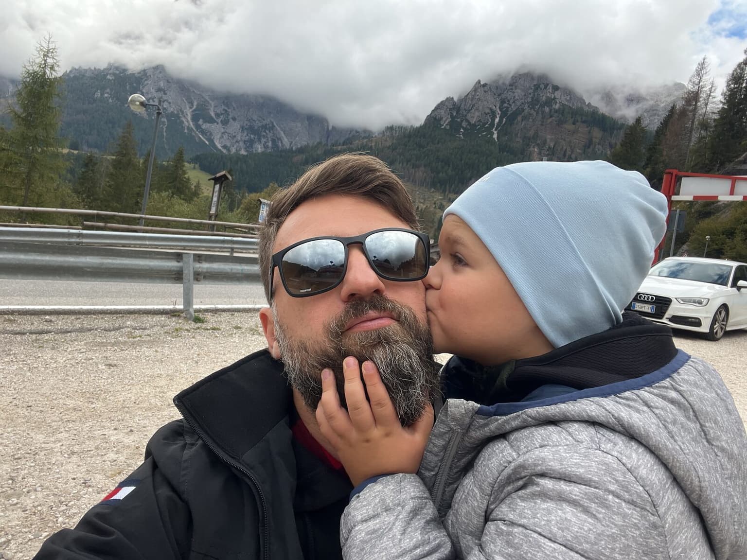 George Mandrovny at a mountain pass in the Dolomites, his young son kissing him on the cheek