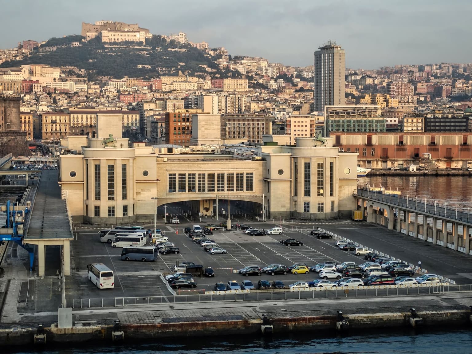 The Stazione Marittima on the Naples waterfront, a pale stone terminal with two rounded towers topped by horse statues