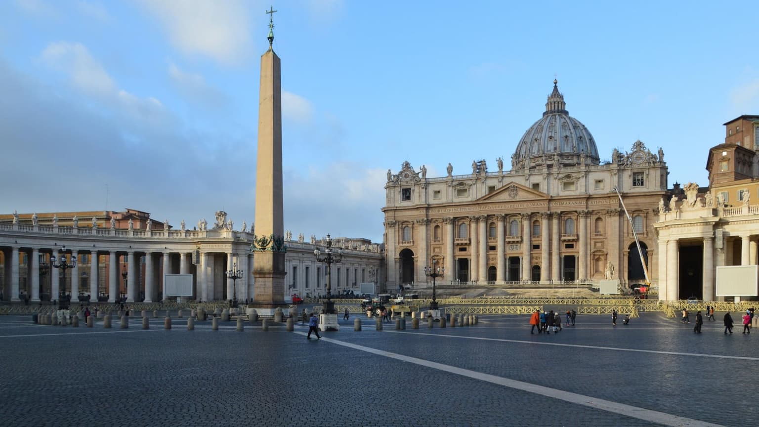 St. Peter's Basilica and its dome rise behind the Egyptian obelisk and colonnade of a nearly empty St. Peter's Square