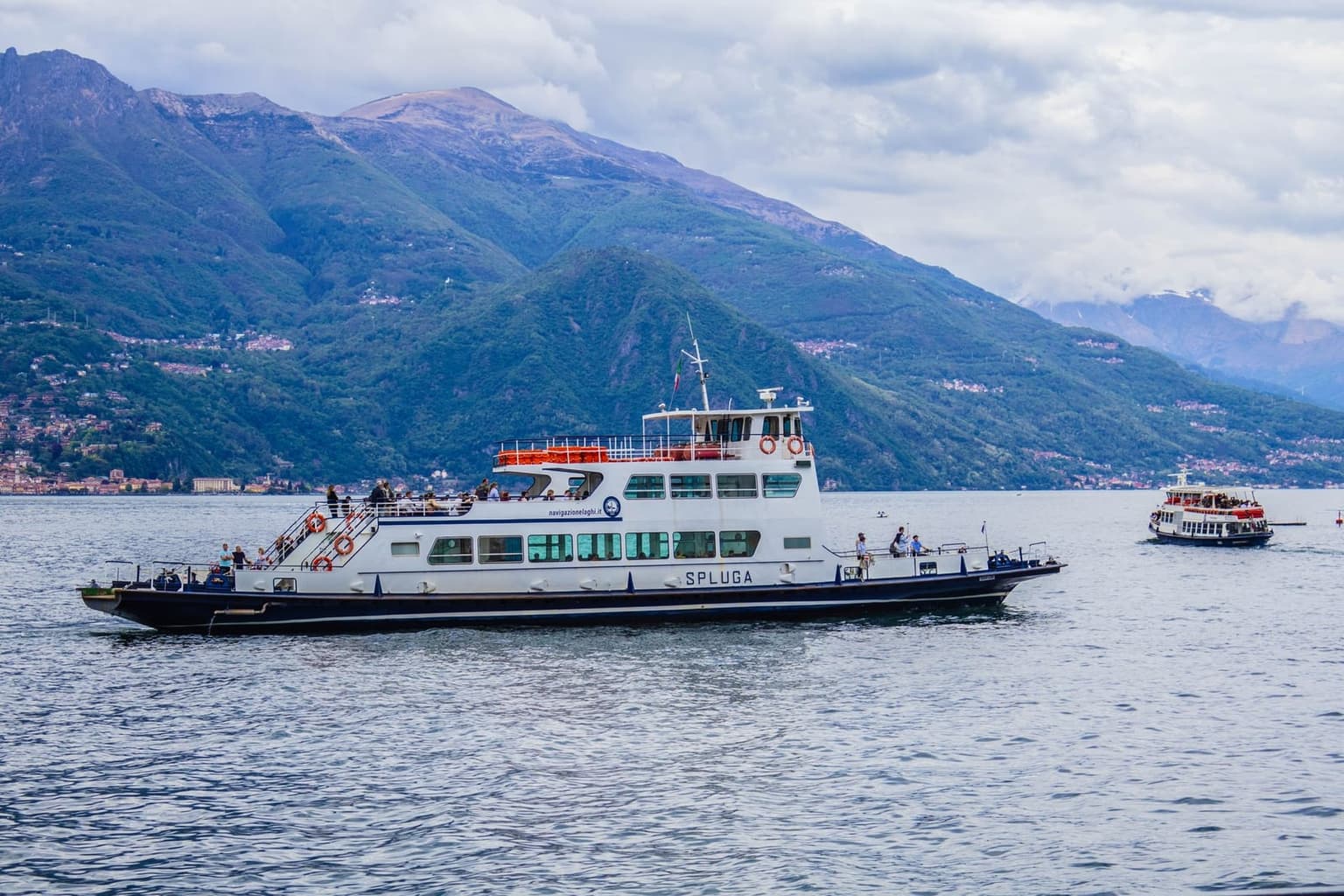 A Navigazione Laghi car ferry crossing Lake Como, mountains behind