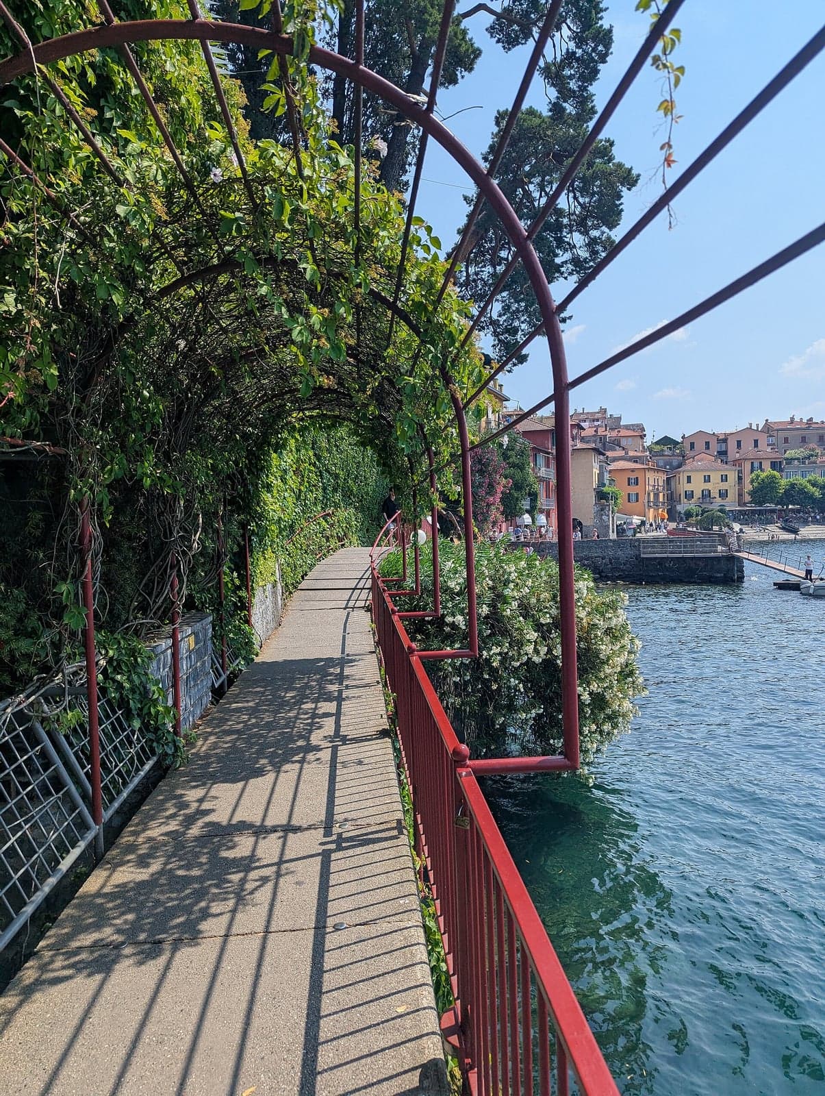 The Passeggiata degli Innamorati, Varenna's cliffside lakeside walkway under its vine-draped red pergola, quiet above the water