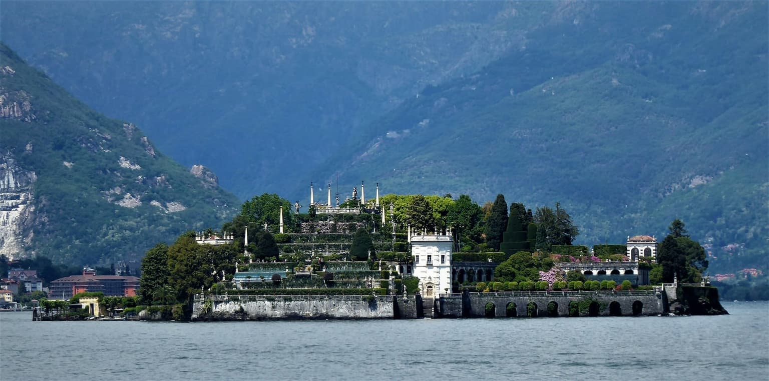 Isola Bella on Lake Maggiore across the water, the palace garden climbing in terraces topped with statues and obelisks, steep forested mountains behind