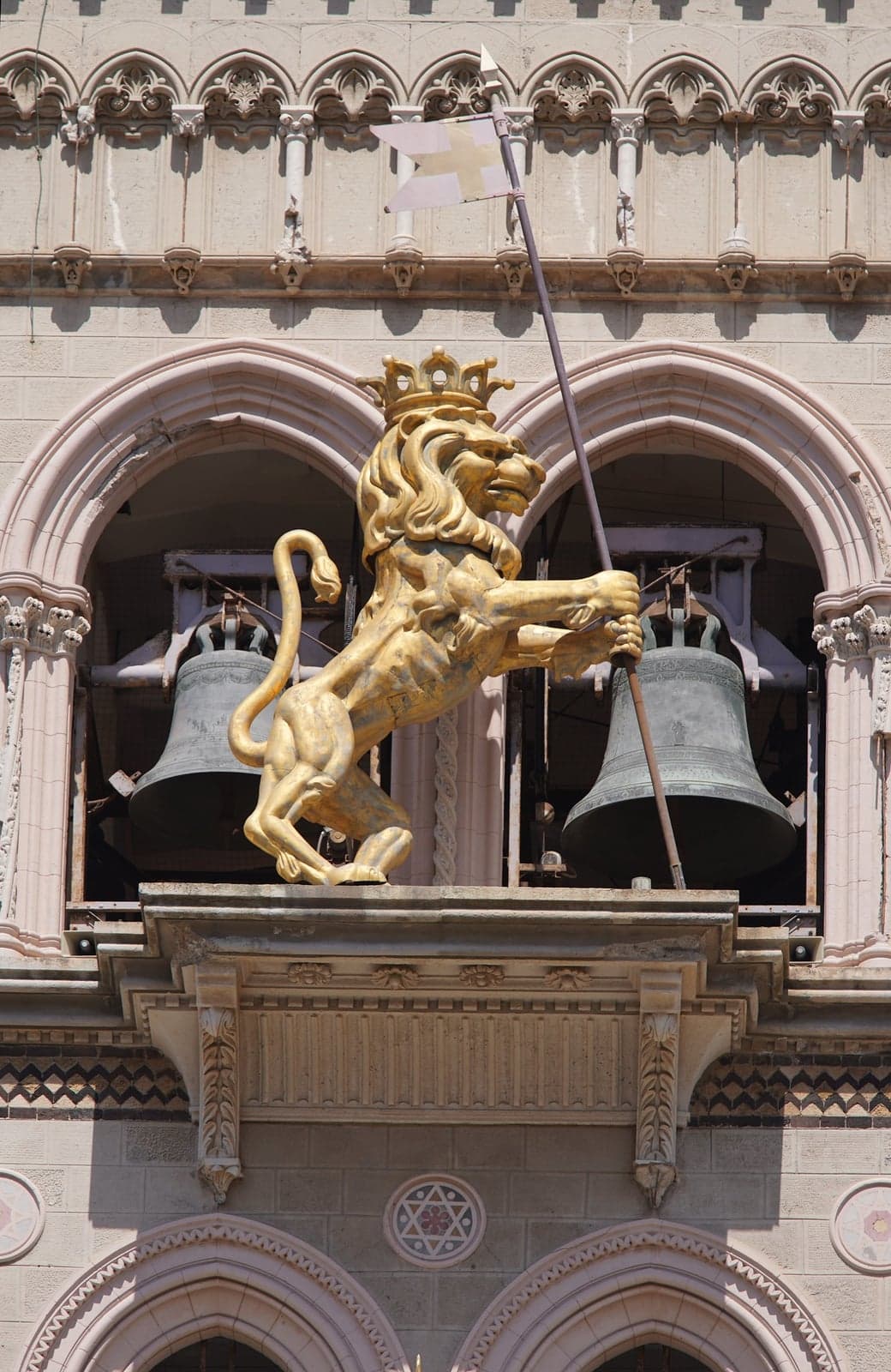 The crowned gilded Lion of Messina rearing between two bronze bells on the Duomo's bell tower, part of the astronomical clock mechanism