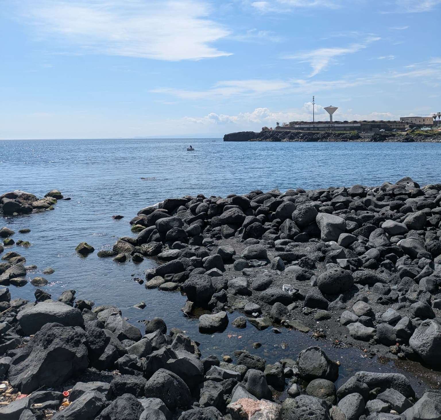 The volcanic rock shoreline at San Giovanni Li Cuti, Catania - black lava rock rather than sand